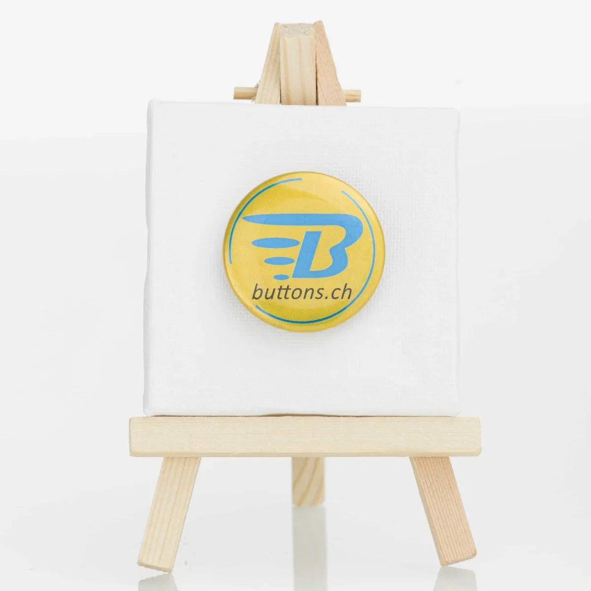 Runder Metallic-Button in Gold, 37 mm, mit blauem buttons.ch-Logo.