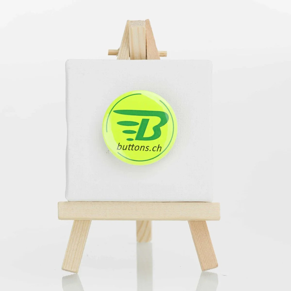 Runder Neonbutton in Neongelb, 37 mm, mit buttons.ch-Logo.